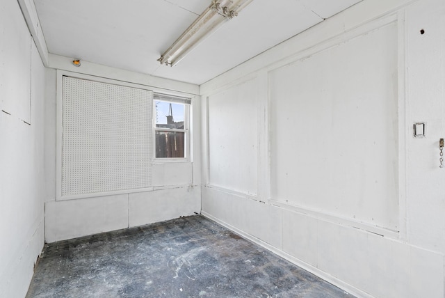 unfurnished room with concrete flooring