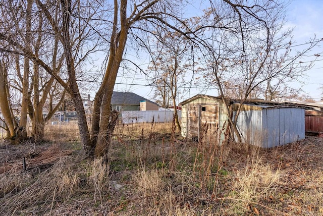 view of yard with a storage shed, an outdoor structure, and fence