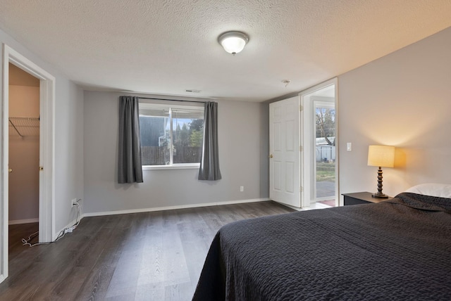 unfurnished bedroom featuring visible vents, baseboards, a textured ceiling, and dark wood-style flooring