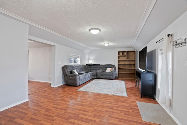 living room featuring baseboards, light wood-style flooring, a textured ceiling, and lofted ceiling