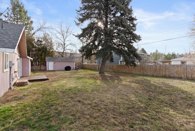 view of yard with an outbuilding, a fenced backyard, and a shed