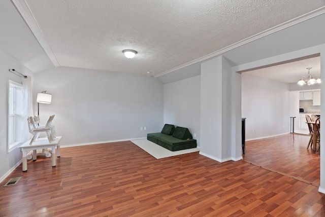 living area featuring visible vents, baseboards, vaulted ceiling, an inviting chandelier, and wood finished floors