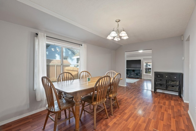 dining space with baseboards, wood finished floors, lofted ceiling, and a chandelier