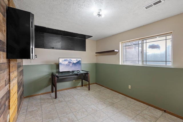 interior space with visible vents, a textured ceiling, and baseboards