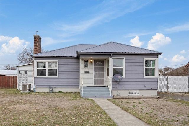 bungalow-style home with cooling unit, fence, a chimney, crawl space, and metal roof