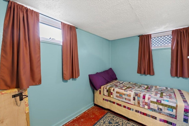 bedroom featuring baseboards and a textured ceiling