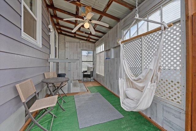 sunroom featuring vaulted ceiling with beams and a ceiling fan