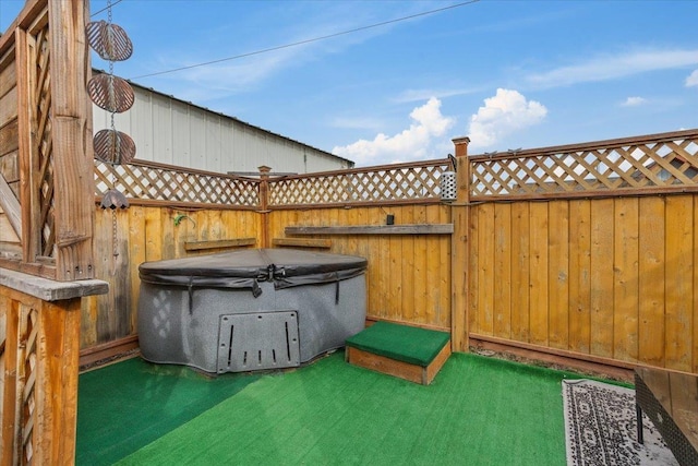 view of patio / terrace with fence and a hot tub