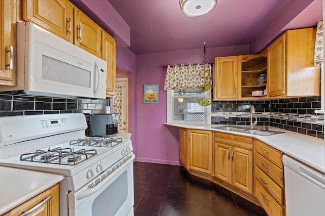 kitchen featuring dark tile patterned floors, a sink, white appliances, light countertops, and decorative backsplash