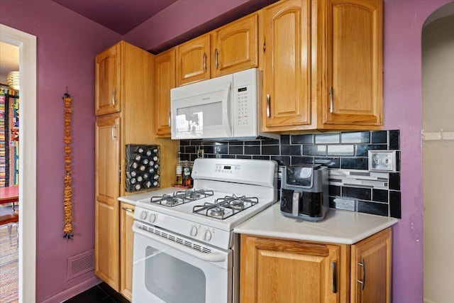 kitchen featuring visible vents, brown cabinets, tasteful backsplash, white appliances, and light countertops