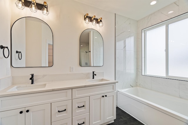 full bath with double vanity, walk in shower, a bathing tub, and a sink