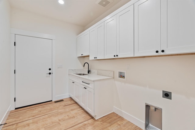 washroom with visible vents, light wood-type flooring, a sink, cabinet space, and hookup for an electric dryer