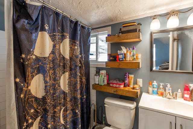 full bathroom with toilet, curtained shower, a textured ceiling, and vanity