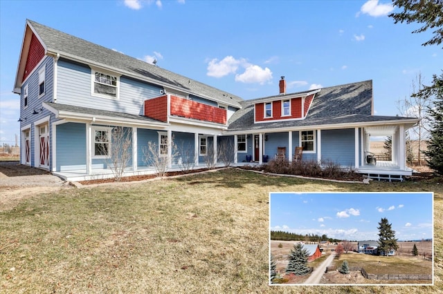 rear view of property featuring a chimney, a lawn, a porch, and an attached garage