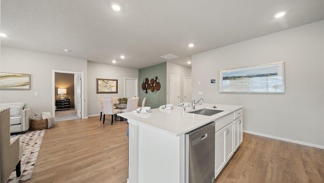 kitchen featuring light wood-type flooring, recessed lighting, stainless steel dishwasher, white cabinetry, and a sink