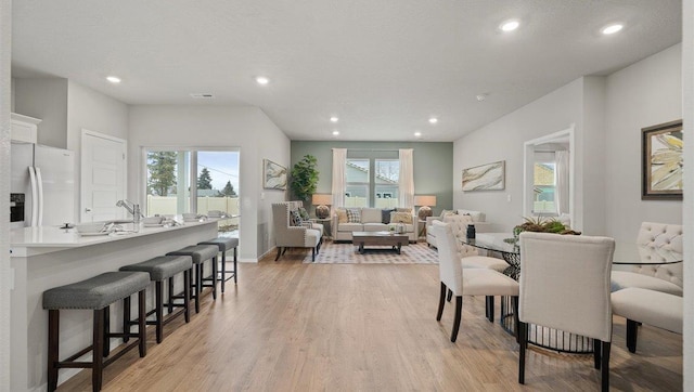 dining space featuring recessed lighting, light wood-type flooring, and baseboards