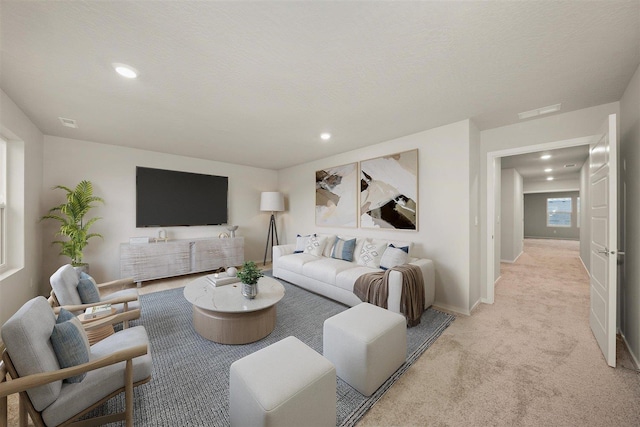 living area with visible vents, recessed lighting, baseboards, and light carpet