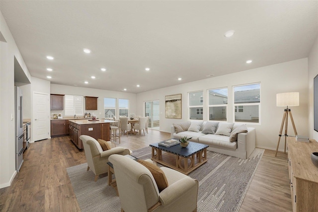 living area with recessed lighting, baseboards, and wood finished floors