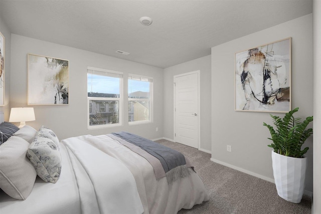 bedroom with visible vents, a textured ceiling, baseboards, and carpet floors