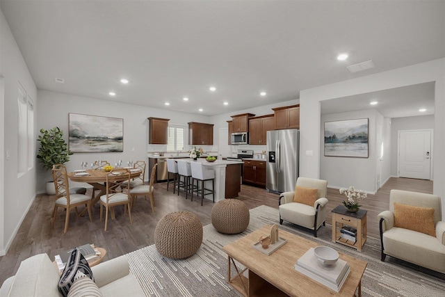 living room with visible vents, recessed lighting, and wood finished floors