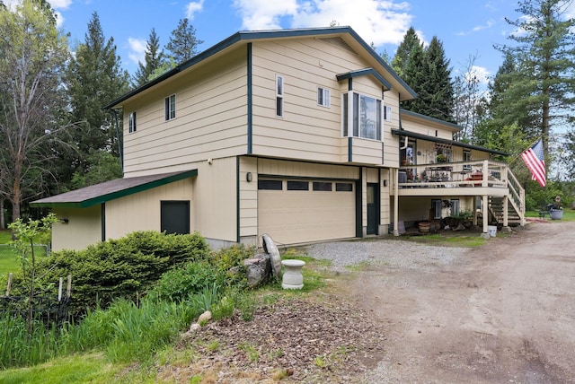 28003 N Hardesty Rd, Chattaroy, WA 99003 - view of front of property with dirt driveway, an attached garage, a wooden deck, and stairway
