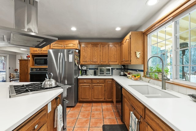 kitchen with light countertops, light tile patterned floors, island exhaust hood, black appliances, and a sink