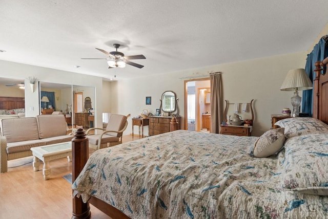 bedroom featuring light wood finished floors, connected bathroom, a textured ceiling, and ceiling fan