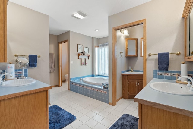 bathroom featuring a sink, visible vents, two vanities, and tile patterned flooring