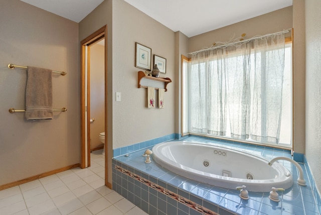 full bath with tile patterned flooring, a tub with jets, toilet, and baseboards