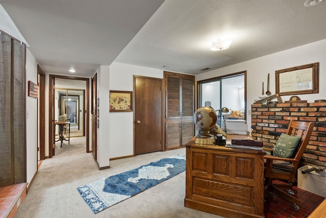 home office featuring a textured ceiling, baseboards, and light carpet