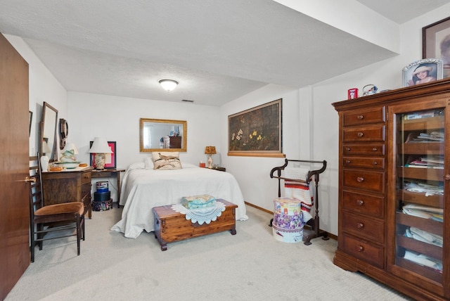 carpeted bedroom featuring visible vents, a textured ceiling, and baseboards