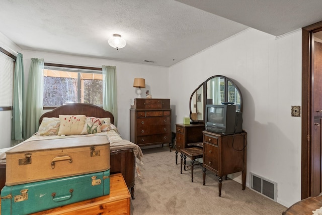 bedroom featuring a textured ceiling, visible vents, and light carpet