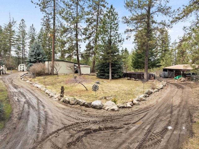 view of road with an outbuilding and dirt driveway