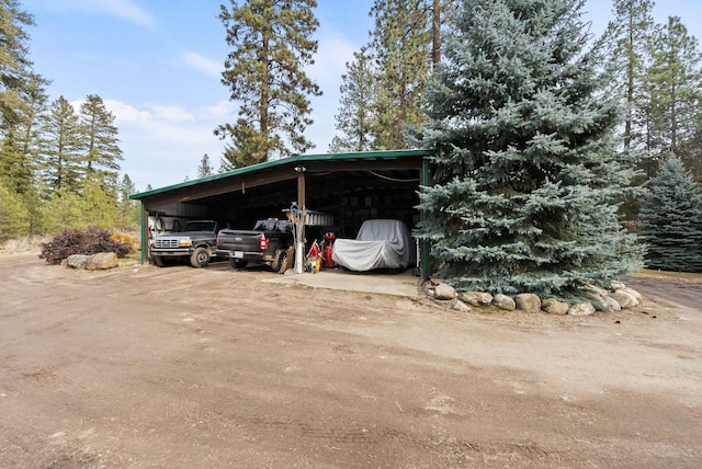 view of vehicle parking with an outbuilding and dirt driveway