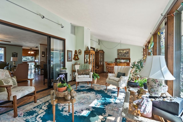 living room with vaulted ceiling, wood finished floors, visible vents, and ceiling fan