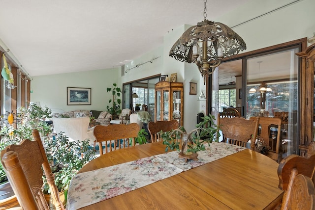 dining room featuring a notable chandelier, plenty of natural light, wood finished floors, and lofted ceiling