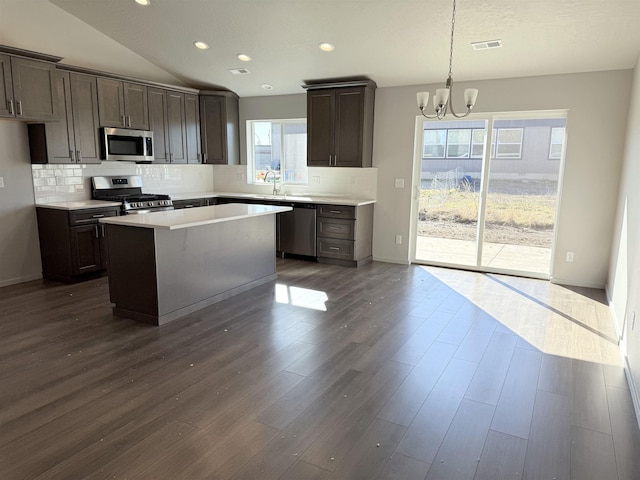 kitchen with visible vents, light countertops, dark wood-style flooring, stainless steel appliances, and a sink