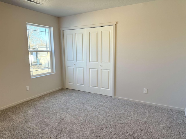 unfurnished bedroom featuring carpet flooring, baseboards, and a closet