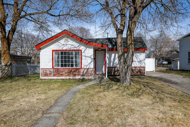 view of front of property featuring driveway, a front yard, and fence