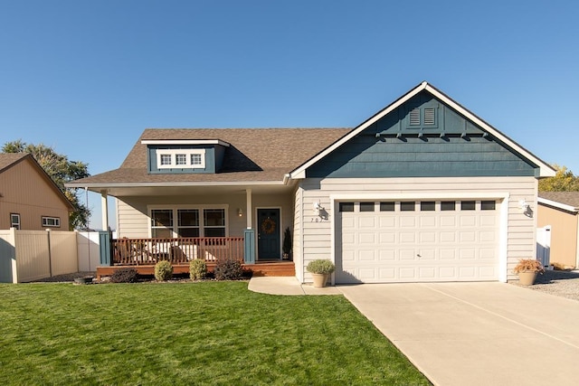 view of front facade with fence, driveway, an attached garage, covered porch, and a front lawn