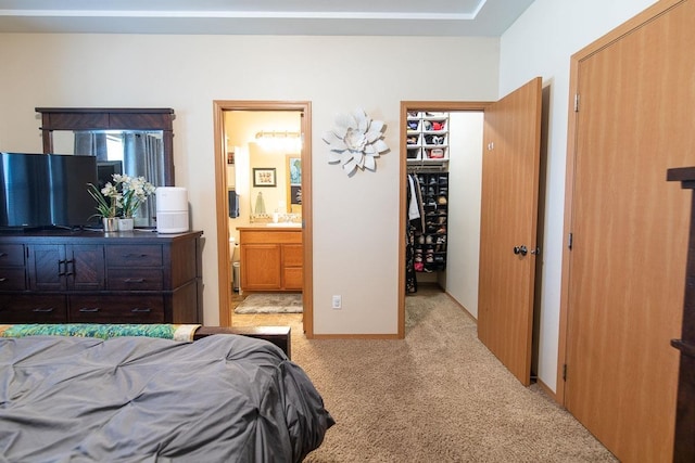 bedroom with connected bathroom and light carpet