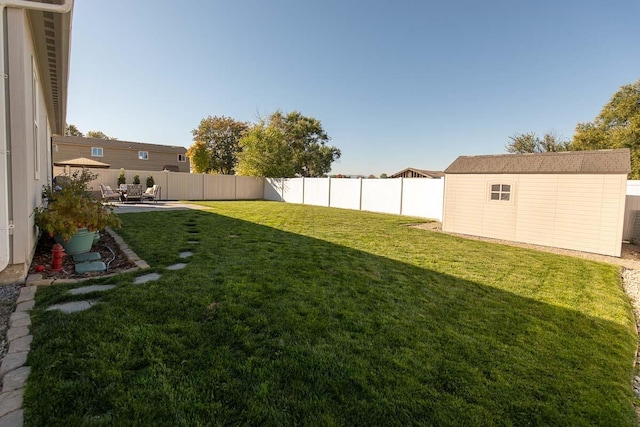 view of yard with a storage unit, a fenced backyard, a patio, and an outdoor structure