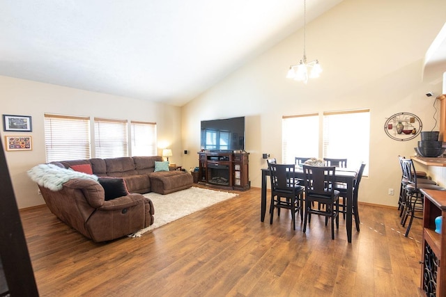 living room featuring baseboards, a notable chandelier, wood finished floors, and high vaulted ceiling