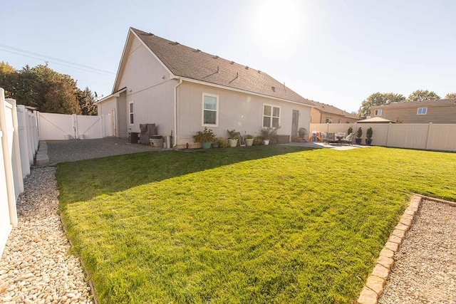 rear view of house with a patio area, a fenced backyard, and a yard