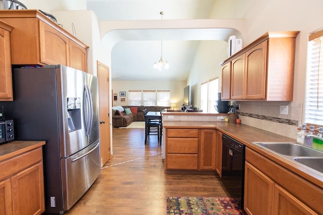 kitchen with lofted ceiling, a peninsula, dark wood-style flooring, stainless steel refrigerator with ice dispenser, and dishwasher