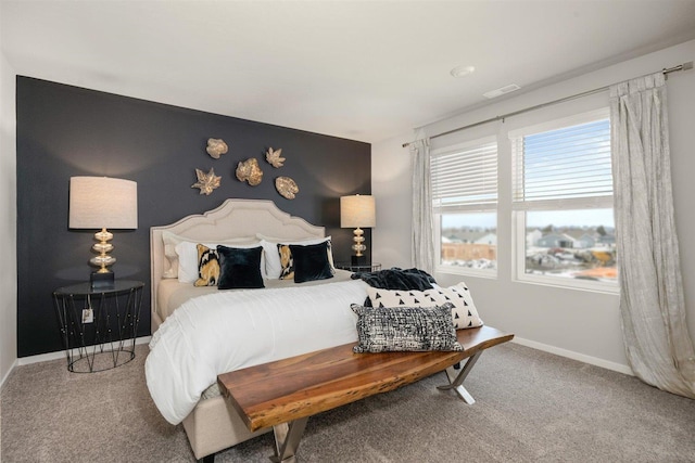 carpeted bedroom featuring visible vents, baseboards, and an accent wall