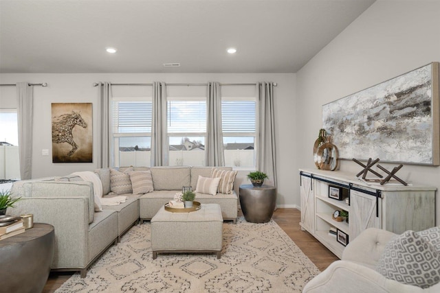 living area featuring visible vents, recessed lighting, baseboards, and wood finished floors