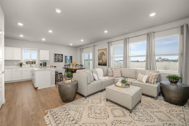 living room with light wood-style flooring and recessed lighting