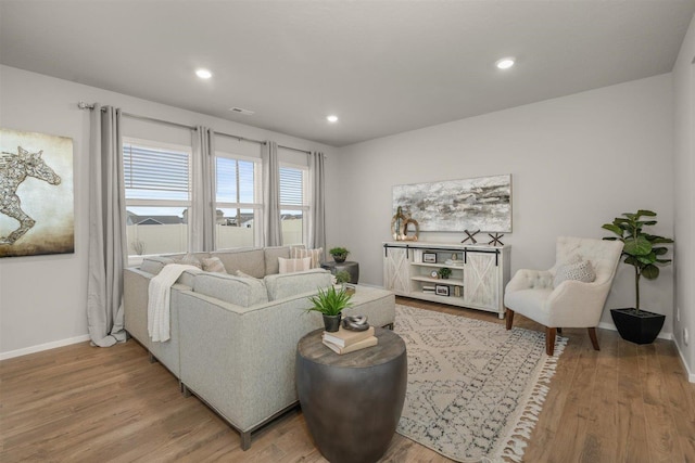 living room with recessed lighting, baseboards, and light wood-style flooring