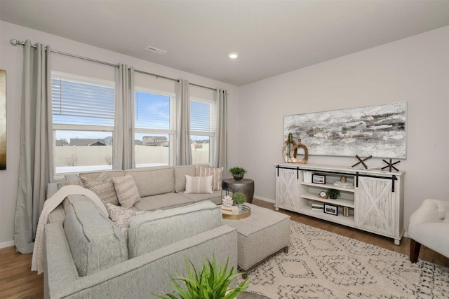 living room with visible vents, recessed lighting, baseboards, and wood finished floors